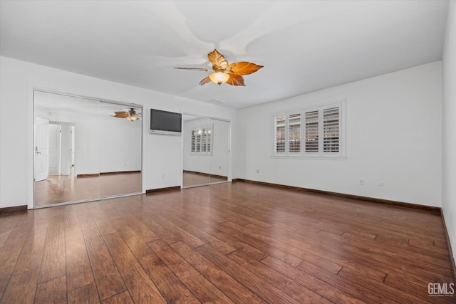 unfurnished living room with ceiling fan and dark hardwood / wood-style floors