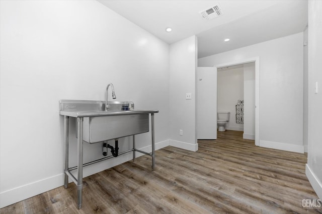 clothes washing area featuring hardwood / wood-style floors