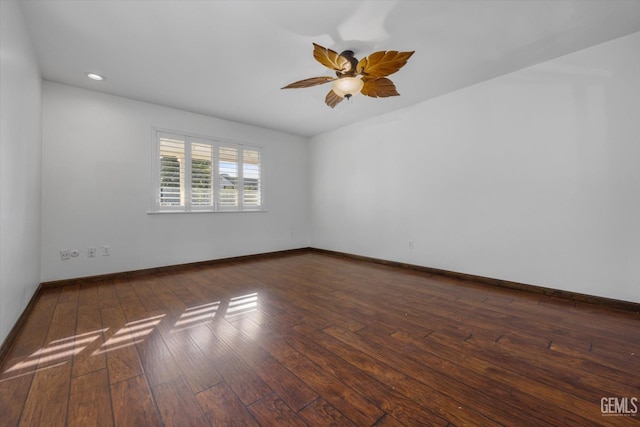 empty room with dark hardwood / wood-style floors and ceiling fan