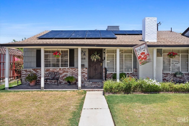 3808 Navajo Ave, Bakersfield, CA 93309 - view of front facade with a front yard, brick siding, a porch, and roof mounted solar panels