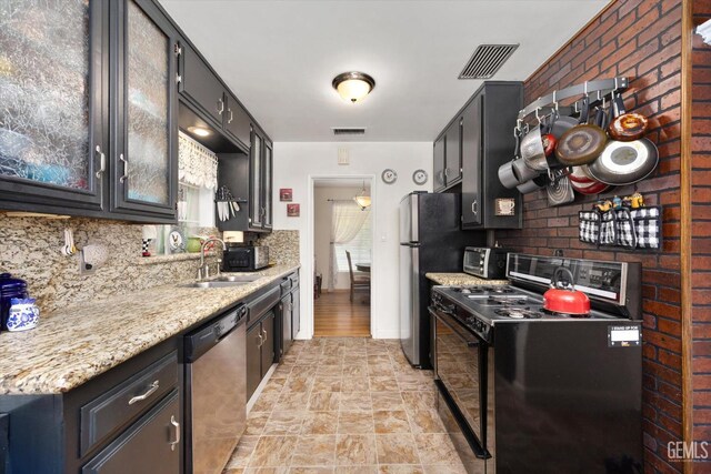 3808 Navajo Ave, Bakersfield, CA 93309 - kitchen with appliances with stainless steel finishes, backsplash, stone finish floors, and dark cabinets