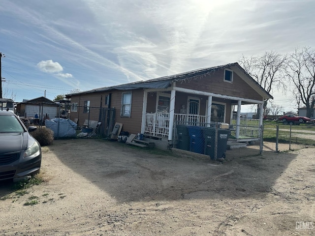 exterior space featuring covered porch and fence