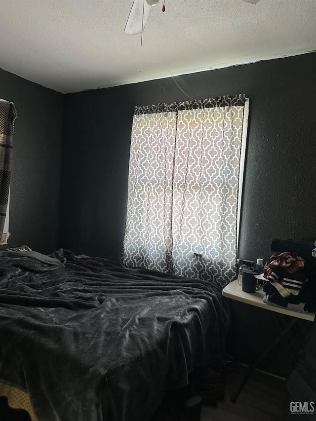 bedroom with a textured ceiling and ceiling fan