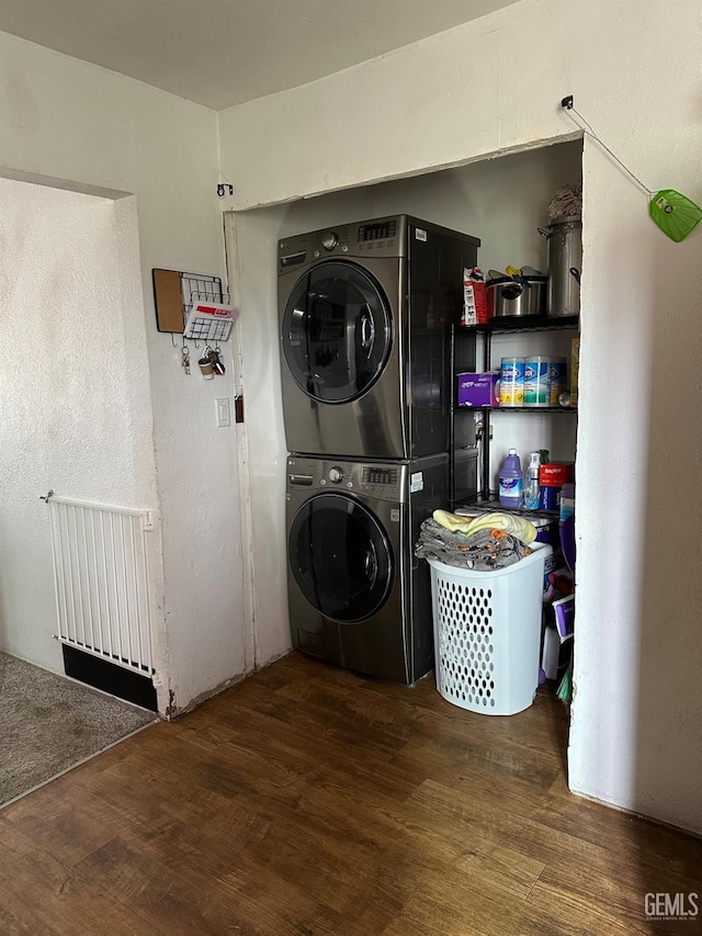 laundry room featuring laundry area, dark wood-style flooring, and stacked washer / drying machine