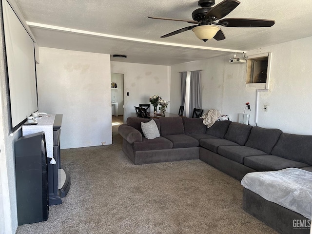 carpeted living room with a ceiling fan and a textured ceiling