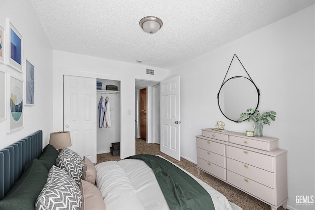 carpeted bedroom with a closet, visible vents, and a textured ceiling