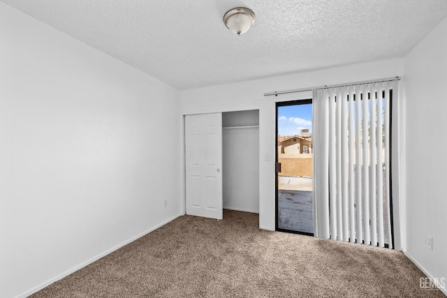 unfurnished bedroom with carpet floors, a closet, and a textured ceiling