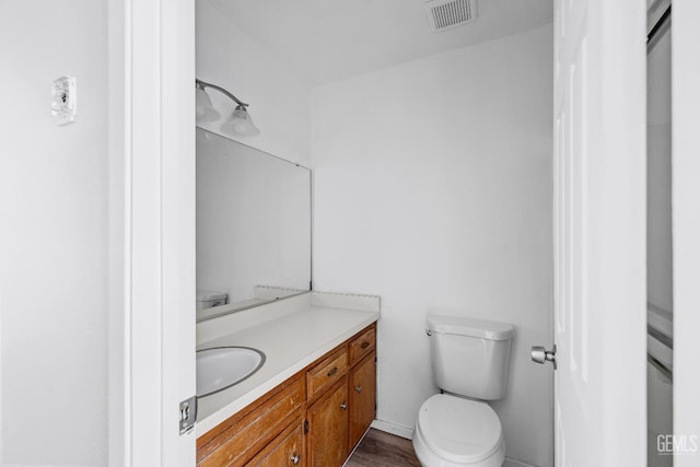 bathroom with visible vents, vanity, and toilet