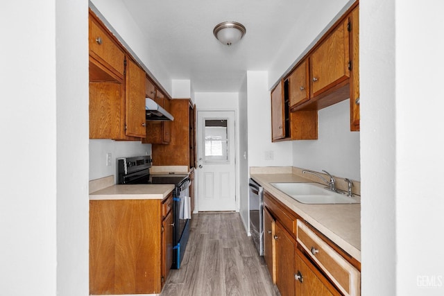 kitchen with a sink, under cabinet range hood, light countertops, and black electric range oven