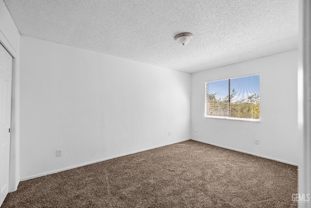 unfurnished bedroom featuring a textured ceiling, carpet floors, a closet, and baseboards