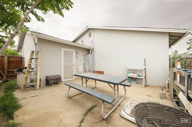 back of property with outdoor dining space, a patio area, stucco siding, and fence