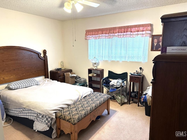 bedroom featuring a ceiling fan, a textured ceiling, and light colored carpet