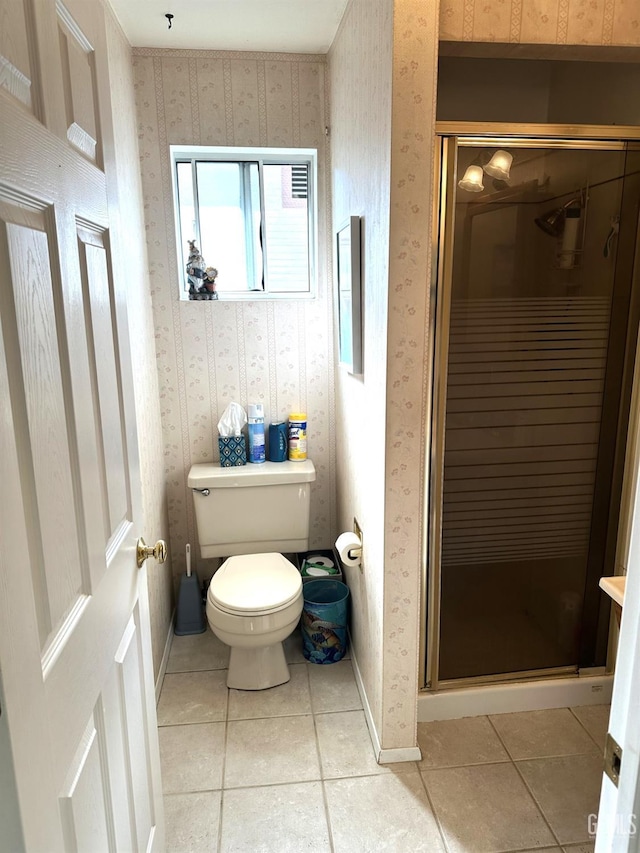 full bath featuring wallpapered walls, toilet, a stall shower, baseboards, and tile patterned floors