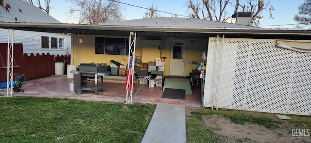 back of house featuring a patio, a yard, and a chimney