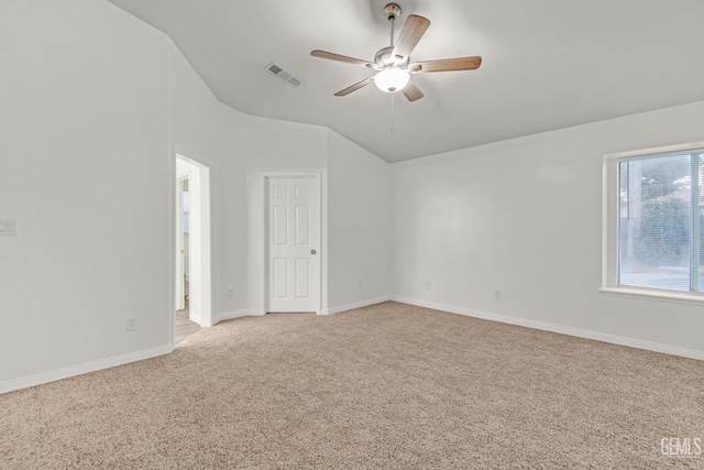 empty room with visible vents, baseboards, light colored carpet, ceiling fan, and vaulted ceiling