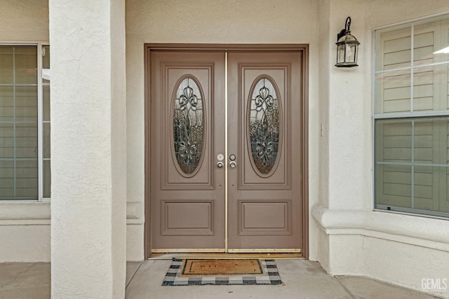 doorway to property featuring stucco siding