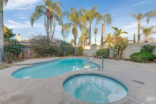 view of swimming pool with a patio area, a fenced backyard, and a pool with connected hot tub