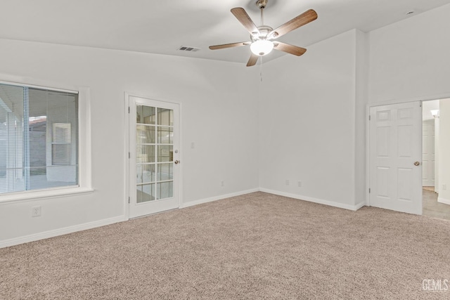 empty room with light colored carpet, ceiling fan, visible vents, and baseboards