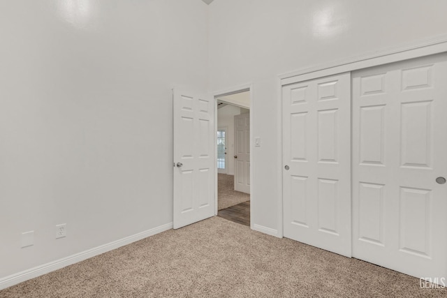 unfurnished bedroom with a closet, baseboards, and carpet flooring