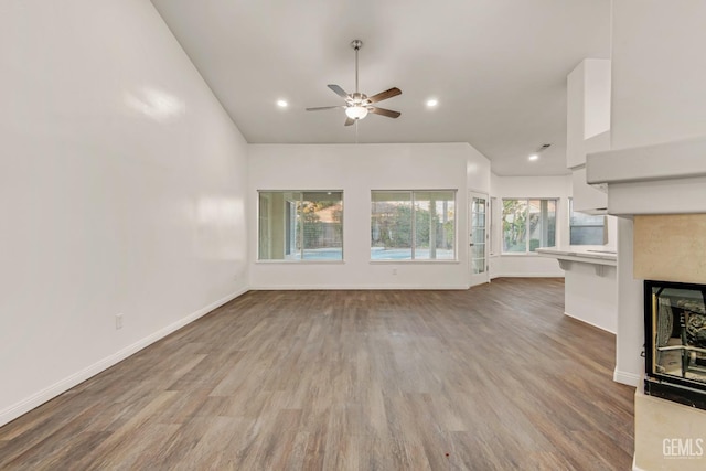 unfurnished living room featuring a fireplace, recessed lighting, ceiling fan, light wood-type flooring, and baseboards