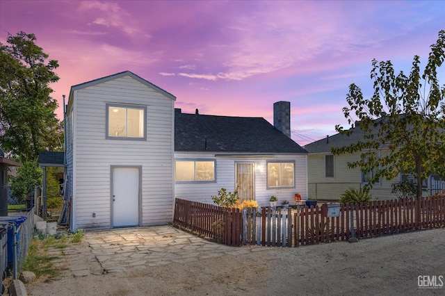 back house at dusk with a patio