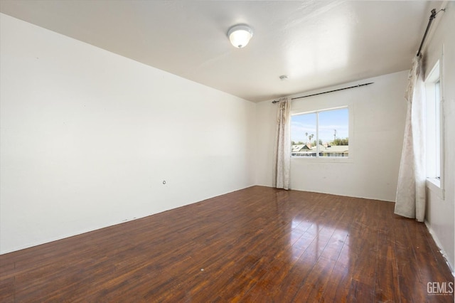 unfurnished room with dark hardwood / wood-style flooring