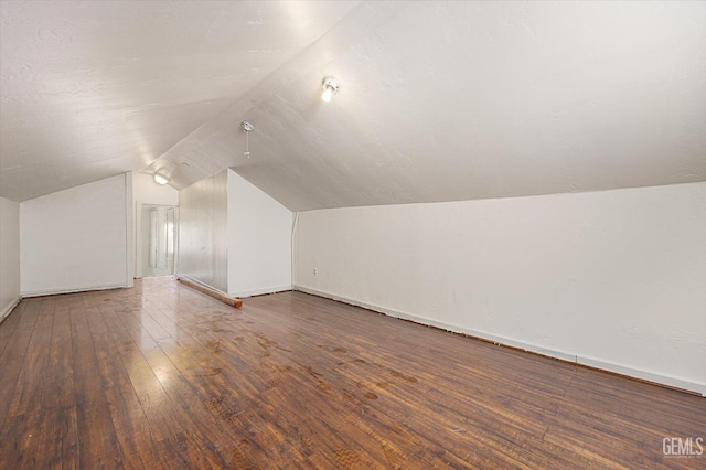 bonus room with lofted ceiling and dark hardwood / wood-style floors