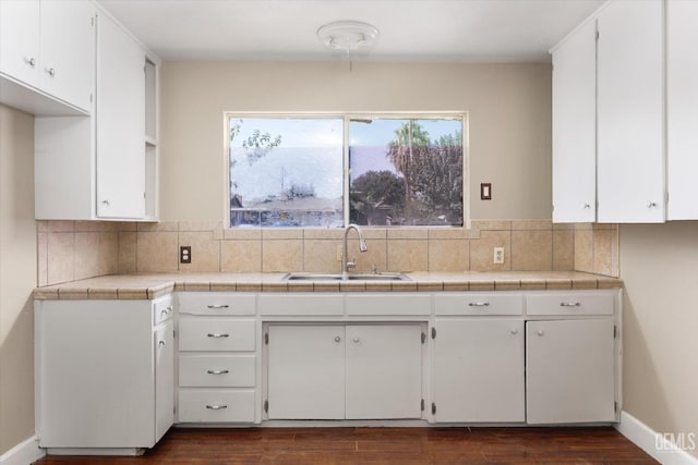 kitchen featuring sink, backsplash, tile counters, white cabinets, and dark hardwood / wood-style flooring