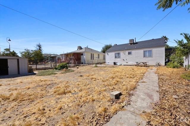 back of house featuring a storage unit