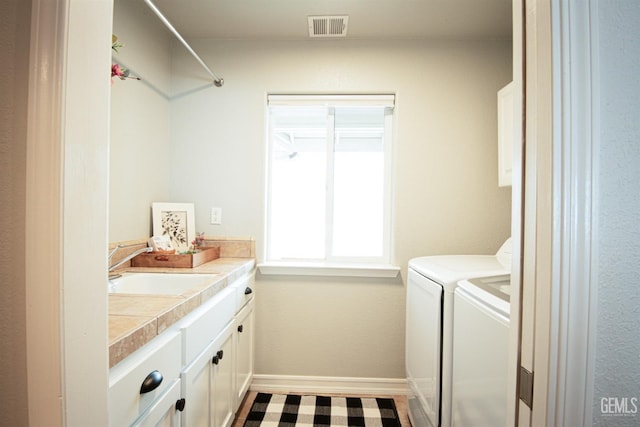 laundry area featuring cabinet space, washing machine and clothes dryer, and baseboards