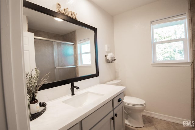 bathroom with toilet, a stall shower, vanity, tile patterned flooring, and baseboards