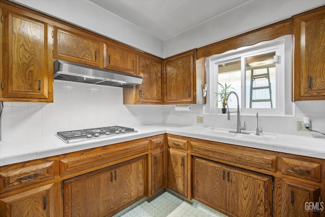 6309 Desert Hills Ave, Bakersfield, CA 93309 - kitchen featuring ventilation hood, stainless steel gas cooktop, brown cabinets, and decorative backsplash