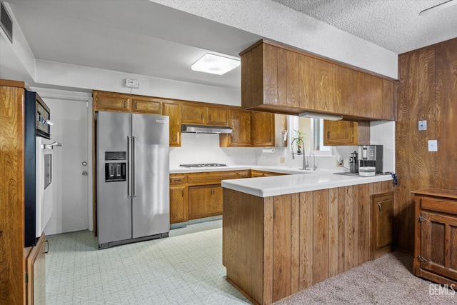 6309 Desert Hills Ave, Bakersfield, CA 93309 - kitchen featuring appliances with stainless steel finishes, a peninsula, brown cabinets, light countertops, and light flooring