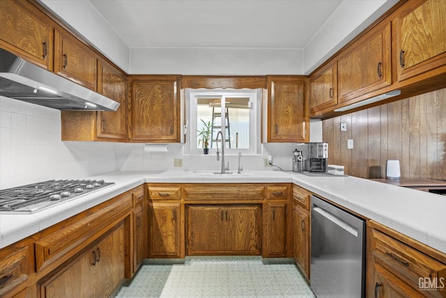 6309 Desert Hills Ave, Bakersfield, CA 93309 - kitchen with appliances with stainless steel finishes, under cabinet range hood, brown cabinets, and decorative backsplash