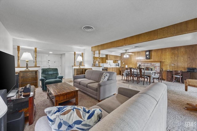 6309 Desert Hills Ave, Bakersfield, CA 93309 - living room featuring carpet flooring, wood walls, ceiling fan, and a textured ceiling