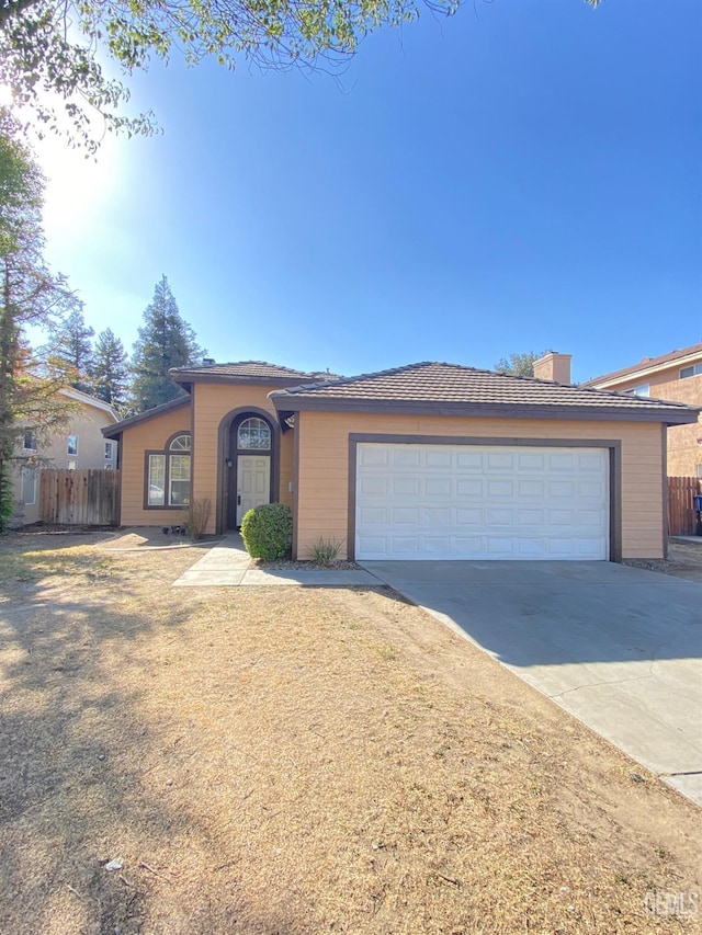 5217 Clover Mountain St, Bakersfield, CA 93313 - view of front of house with concrete driveway, a chimney, and a garage