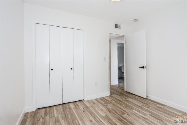 unfurnished bedroom featuring a closet and light hardwood / wood-style flooring