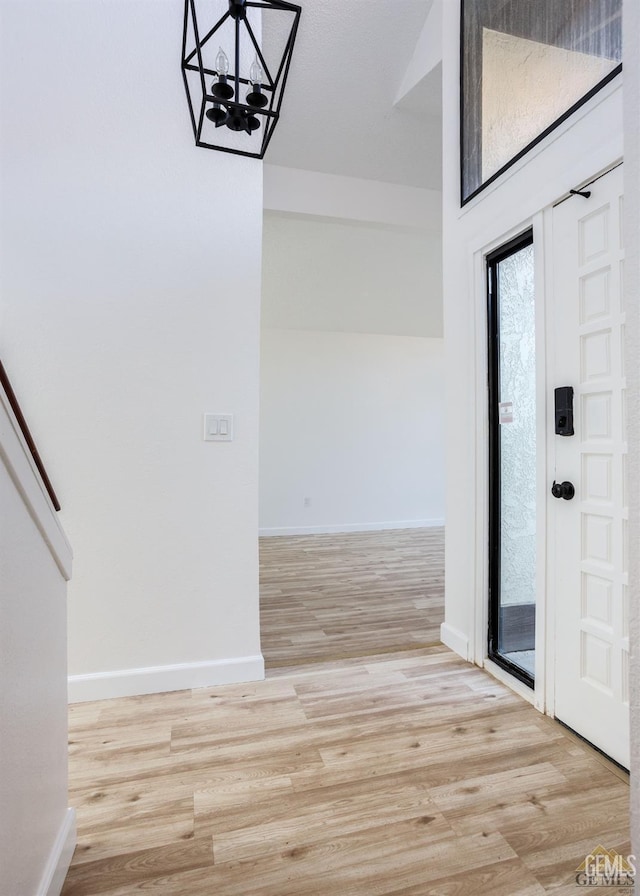 foyer with light hardwood / wood-style flooring and a chandelier