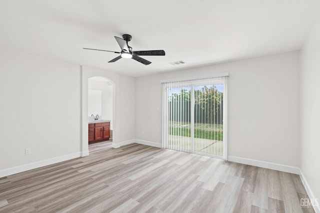 9610 Tahiti Ave, Bakersfield, CA 93311 - empty room with arched walkways, ceiling fan, and light wood finished floors