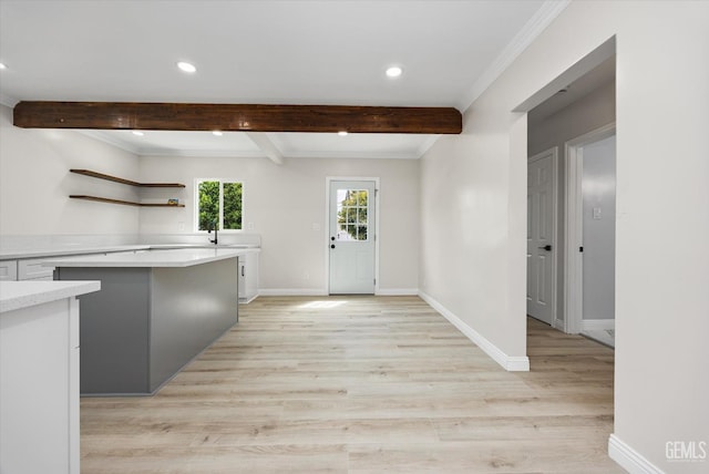 interior space with light countertops, recessed lighting, beamed ceiling, and baseboards