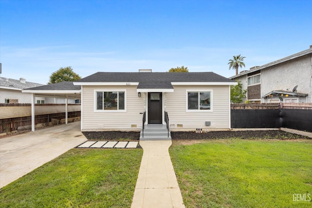 bungalow featuring concrete driveway, fence private yard, and a front lawn