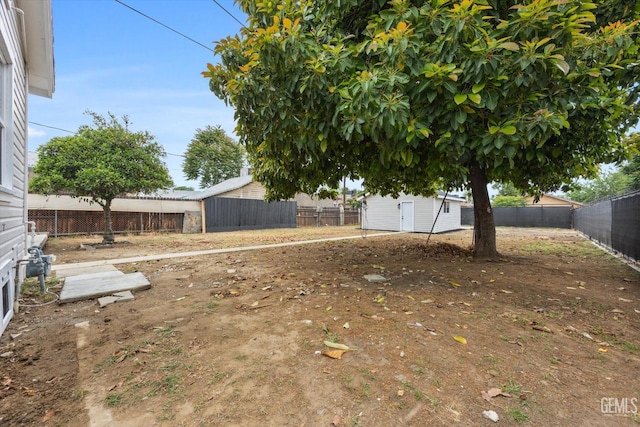 view of yard with a fenced backyard, a storage unit, and an outdoor structure