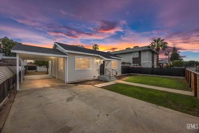 tri-level home featuring fence, driveway, a front yard, and a carport