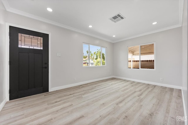 foyer with baseboards, visible vents, ornamental molding, and light wood-style floors
