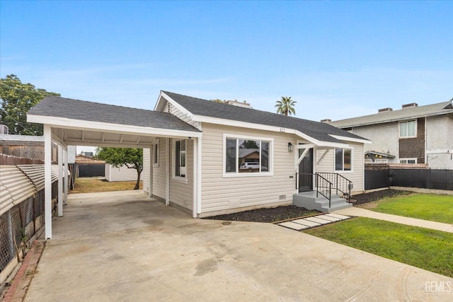 view of front of home with fence, an attached carport, driveway, and a front yard
