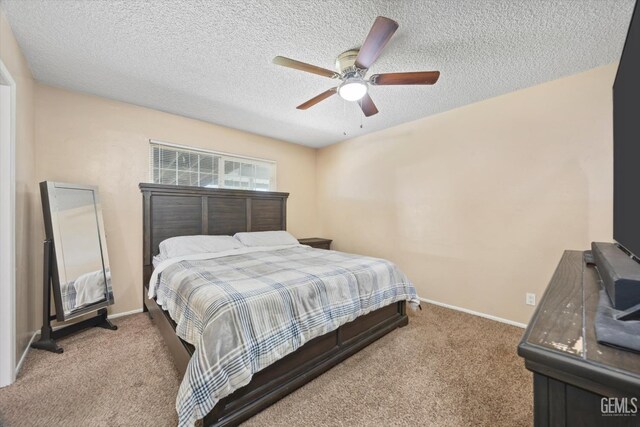 carpeted bedroom with ceiling fan, a textured ceiling, and baseboards