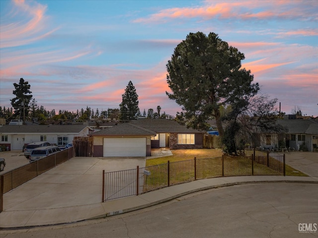 single story home with a fenced front yard, driveway, an attached garage, and a front yard