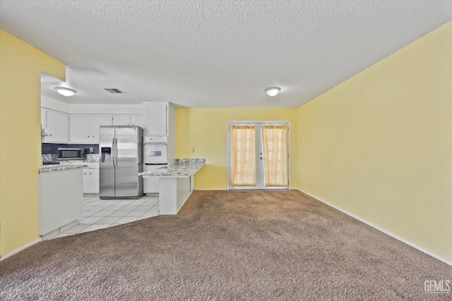 kitchen featuring french doors, visible vents, appliances with stainless steel finishes, and light carpet