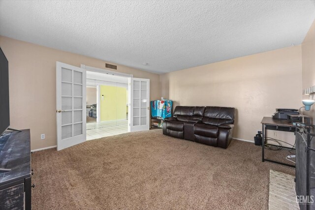 carpeted living room featuring baseboards, french doors, visible vents, and a textured ceiling