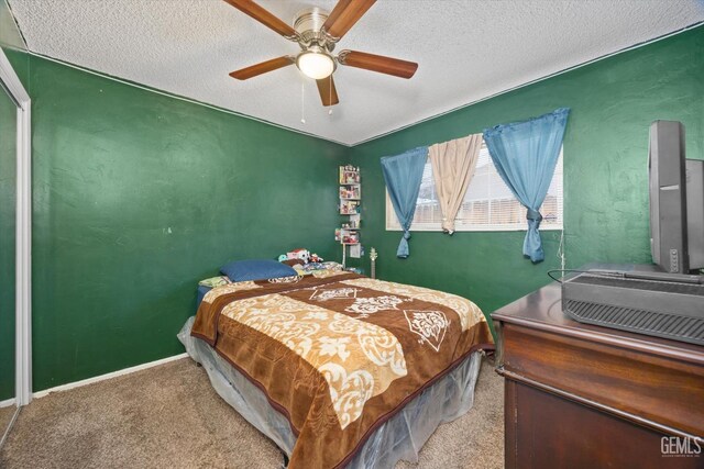 carpeted bedroom with a ceiling fan, baseboards, and a textured ceiling